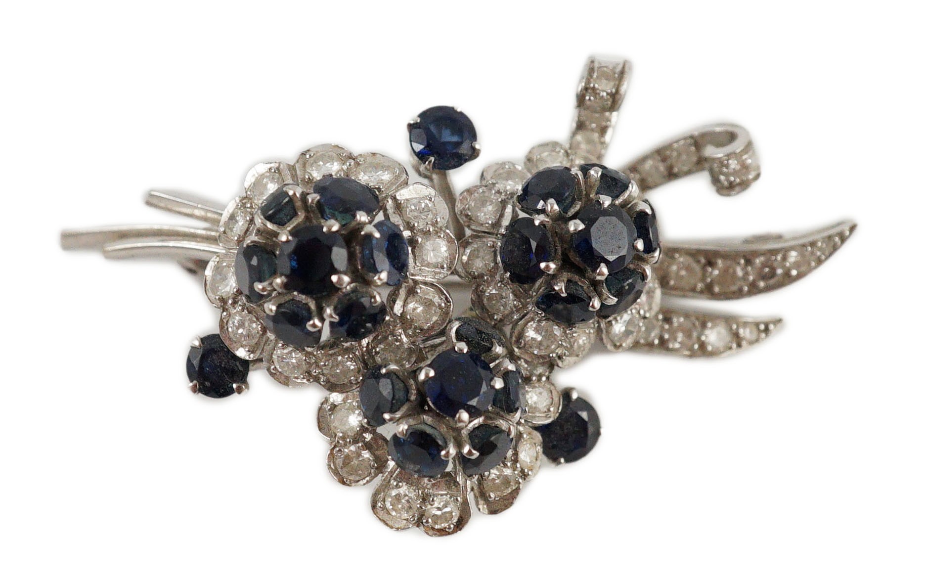 A white gold, sapphire and diamond cluster set floral spray brooch